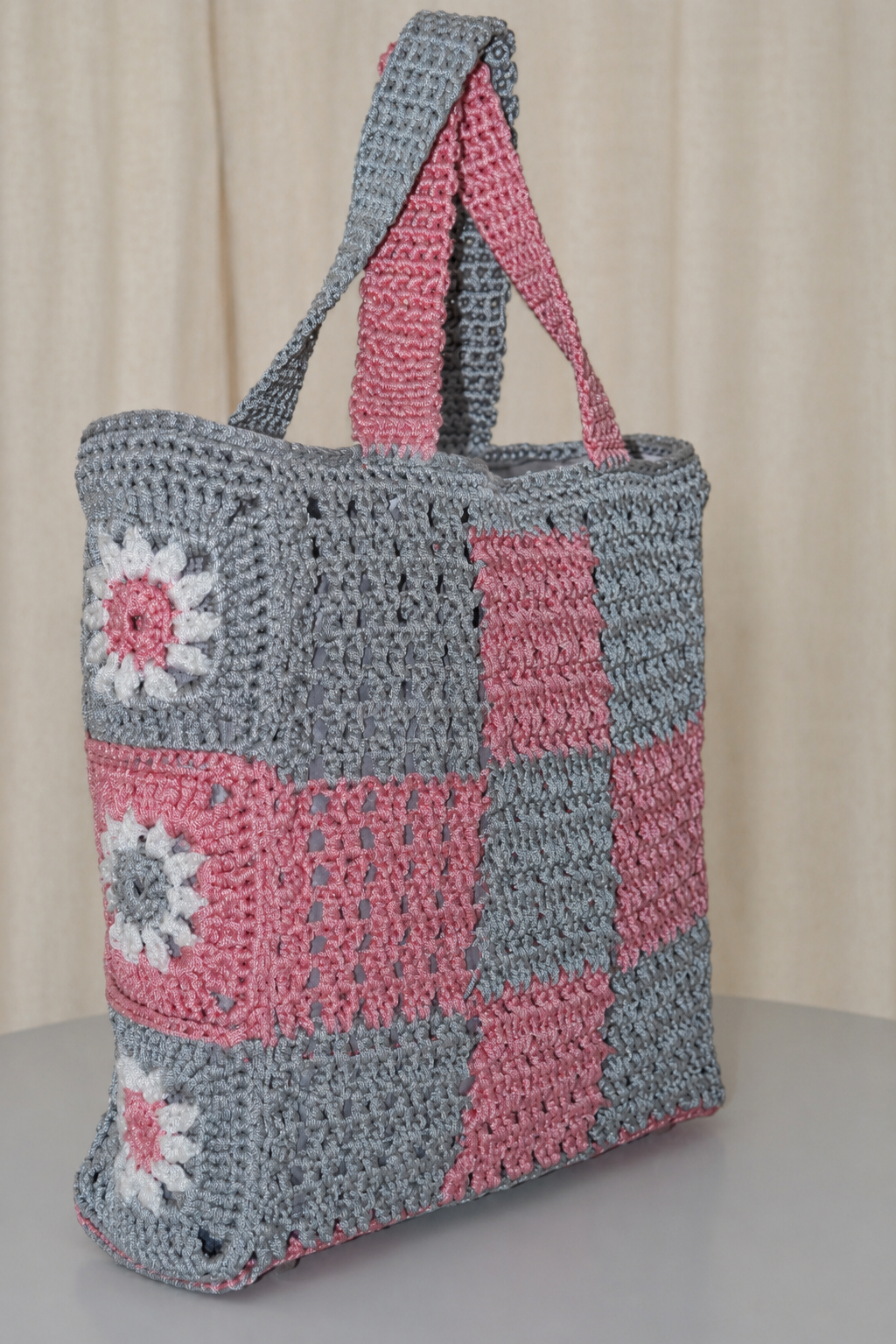 Grand sac au crochet fait main gris et rose à motif damier avec fleurs en granny square et pochette assortie, création artisanale Nouna Tissages.